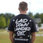 Person wearing a black t-shirt with white text outdoors